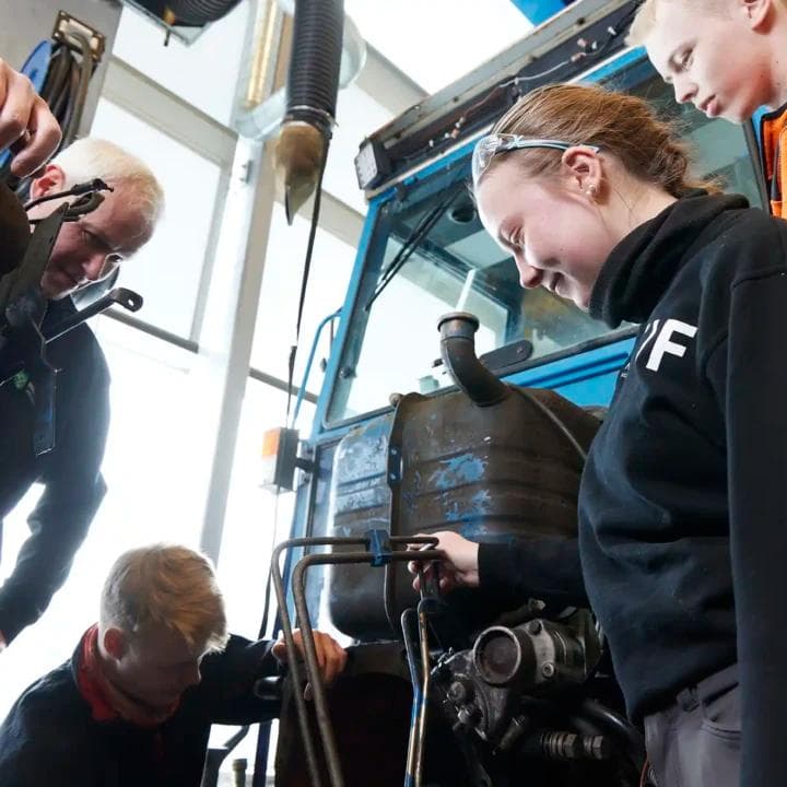 Lærere viser elever å mekke på traktor